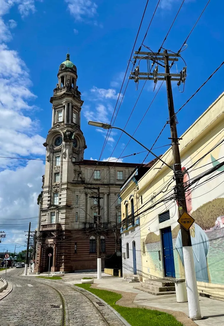 Torre de um prédio histórico do centro de Santos, sob céu azul