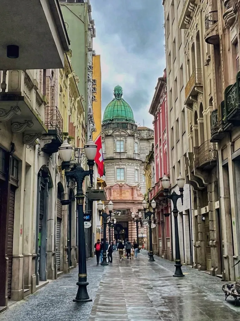 Rua do centro histórico de Santos com a cúpula verde ao fundo